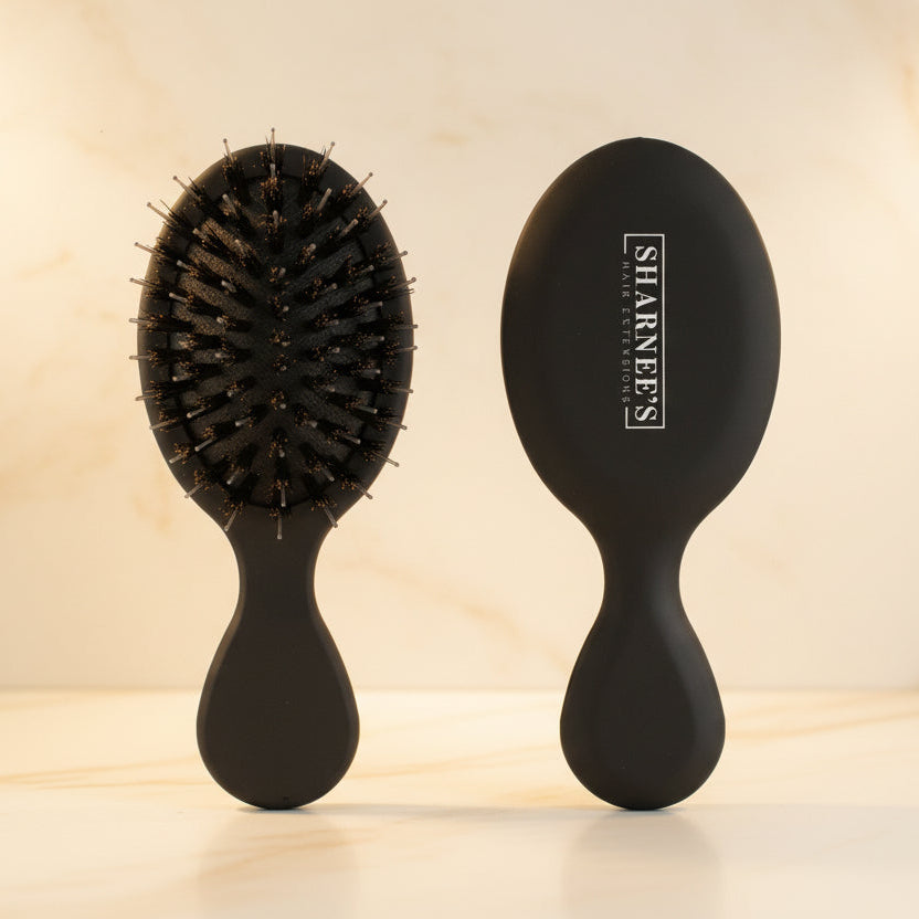 Black hairbrush with bristles on a beige background