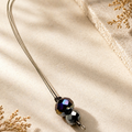Necklace with beaded pendant on a beige fabric background